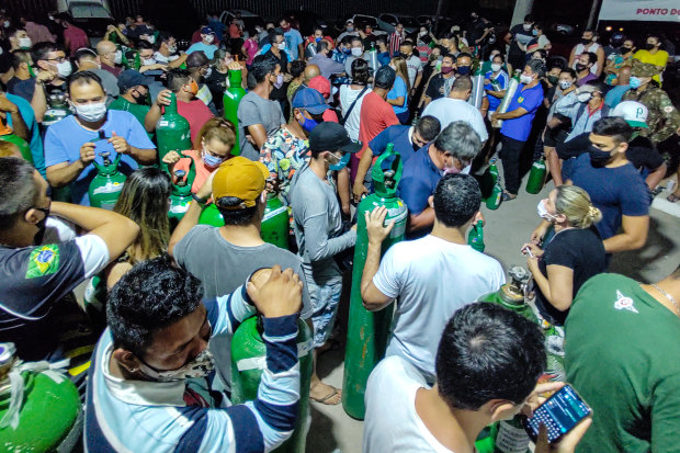 People with oxygen bottles outside an oxygen supplier in Manaus, Brazil during a second wave of COVID that may have been caused by a variant. 