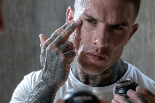 A model applying War Paint concealer. Make-up targeted at Australian men.