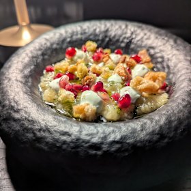 Melanzanasalata is a roasted eggplant dip studded with pomegranates and shards of pork belly crackling.