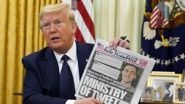 President Donald Trump holds up a copy of the New York Post as he speaks before signing an executive order aimed at curbing protections for social media giants.
