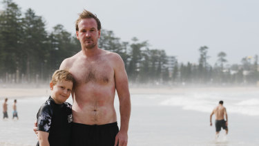 Scott Folkard with his son Jarvis. Mr Folkard rescued a man caught in a rip on Manly beach on Thursday.  An experienced swimmer, he heard the man calling for help before dropping below the surface. Mr Folkard emerged covered in bluebottle stings. 
