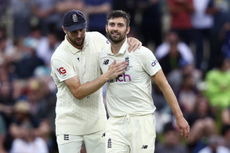 England’s Mark Wood (right) is congratulated by teammate Chris Woakes after Wood took six wickets in Australia’s second innings.