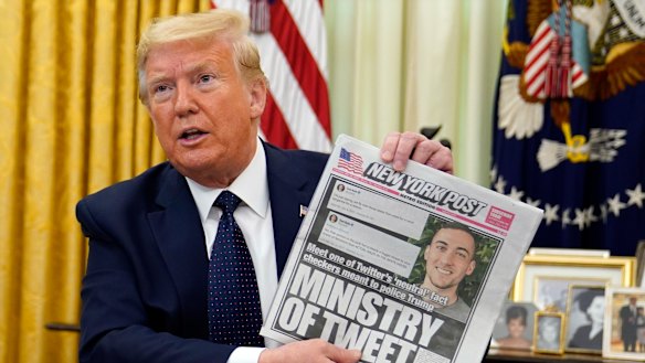 President Donald Trump holds up a copy of the New York Post as he speaks before signing an executive order aimed at curbing protections for social media giants.