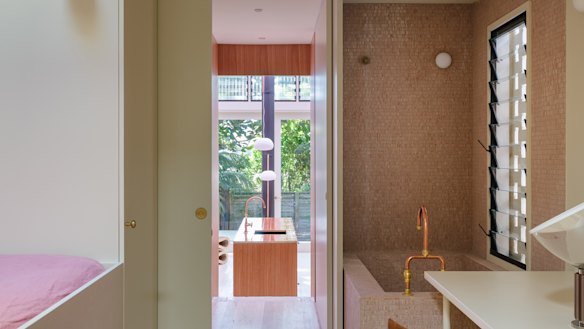 A cream palette is complemented by dusty pink mosaics and glossy amber tiles.