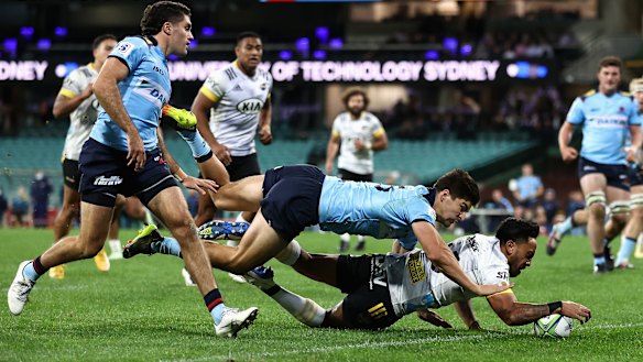 Hurricanes player Pepesana Patafilo barges over against the Waratahs.
