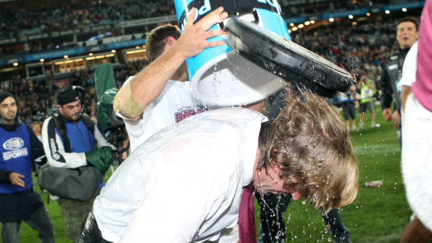 Watershed: Hasler is dunked after the Sea Eagles' 2011 NRL grand final triumph.