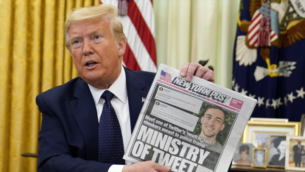 President Donald Trump holds up a copy of the New York Post as he speaks before signing an executive order aimed at curbing protections for social media giants.