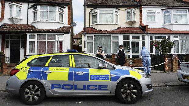 Police officers attend the scene where a women who was around eight months pregnant was stabbed to death in Croydon, south London.
