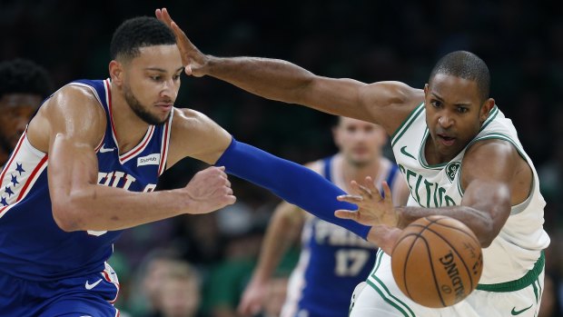 Ben Simmons and Al Horford contest a loose ball.