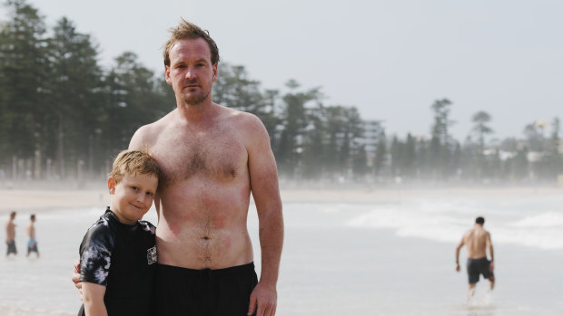 Scott Folkard with his son Jarvis. Mr Folkard rescued a man caught in a rip on Manly beach on Thursday.  An experienced swimmer, he heard the man calling for help before dropping below the surface. Mr Folkard emerged covered in bluebottle stings. 