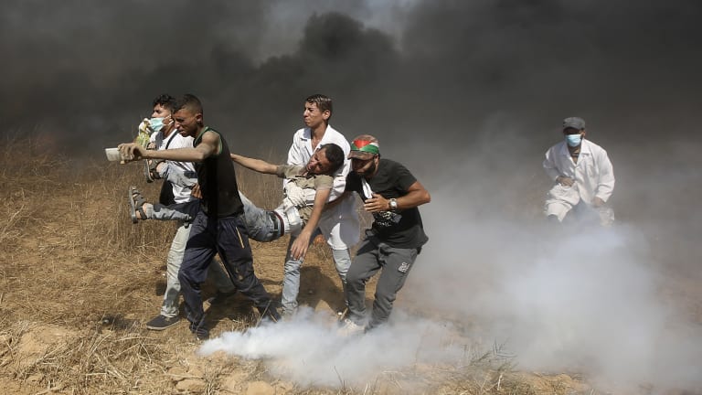 Palestinian medics evacuate a wounded youth near the Gaza Strip's border with Israel, during a protest east of Khan Younis, in the Gaza Strip in June.