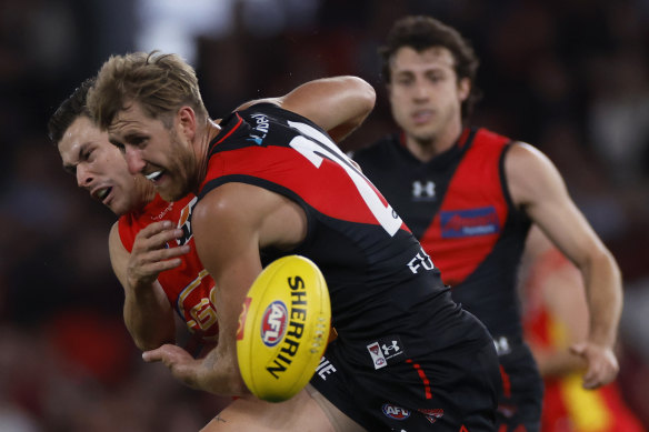 Essendon’s Dyson Heppell clashes with Gold Coast’s Ben Ainsworth before he was subbed out of the game.