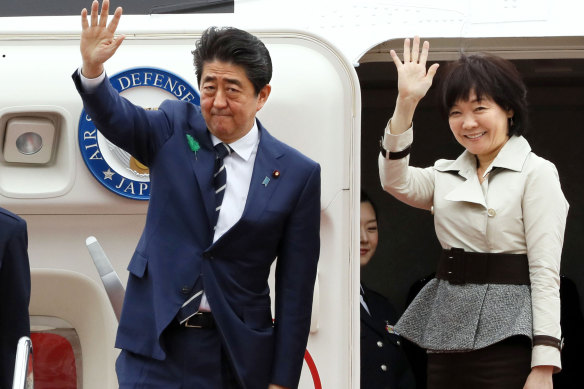 Shinzo Abe waves with his wife Akie Abe while boarding a plane heading for the US in 2018.