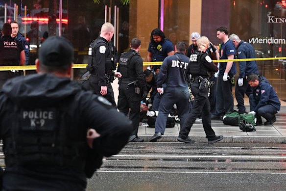 Members of the United States Secret Service tend to a wounded man at the scene of a shooting.