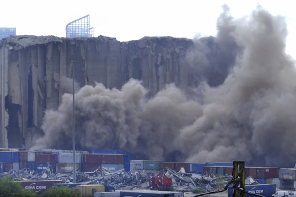 Dust rises in the port of Beirut after a section of the massive grain silos, shredded in the explosion, collapsed.