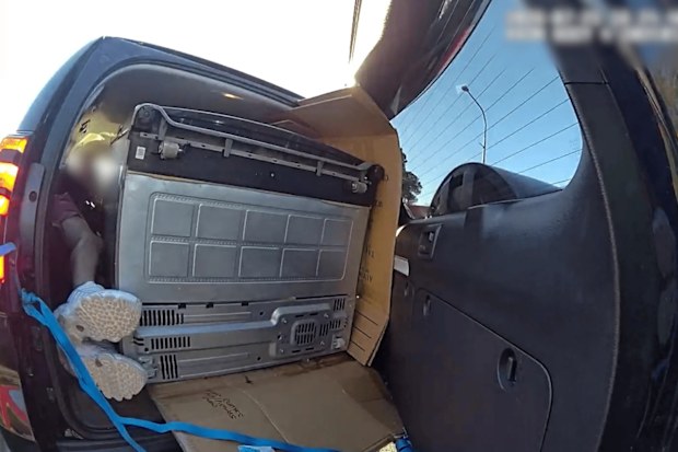 A Brisbane man has been fined more than $1000 after he was found laying down next to a fridge inside a moving car.