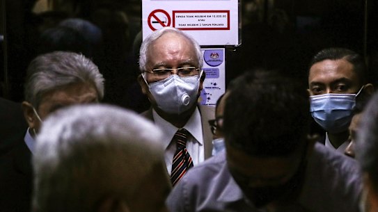 Former Malaysian Prime Minister Najib Razak, center, arrives at the Kuala Lumpur High Court complex in Kuala Lumpur, Malaysia, Tuesday, July 28, 2020. Najib was convicted Tuesday of crimes involving the multibillion-dollar looting of a Malaysian state investment fund that brought down his government in a shocking election ouster two years ago.(Fazry Ismail/Pool Photo via AP)