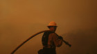 A firefighter monitors the blaze in Mandeville Canyon.