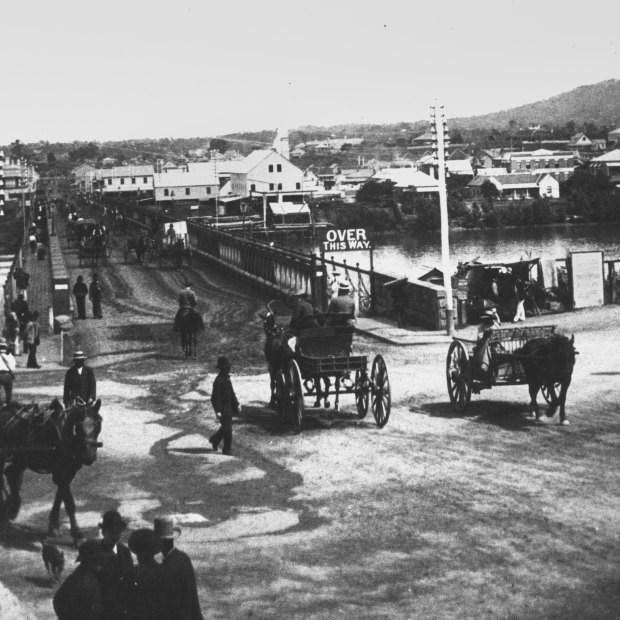 Horse drawn carraiges and pedestrians at the northern approach of the first permanent Victoria Bridge, ca 1885.