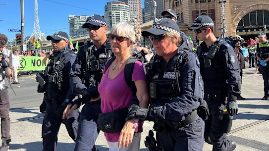 A protester is led away by police. 