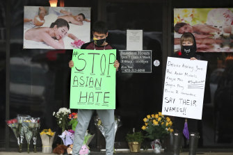 After dropping off flowers Jesus Estrella, left, and Shelby S., right, stand in support of the Asian and Hispanic community outside Youngs Asian Massage parlour near Atlanta where four people were killed.