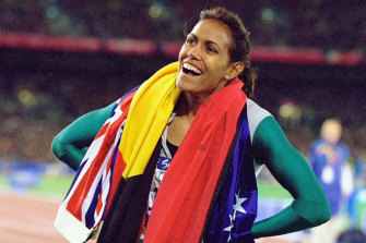 Cathy Freeman celebrates her Sydney Olympic gold medal win with the Aboriginal and Australian flags. 