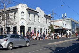 People congregate outside the Peacock Inn, on High Street in Northcote, on Sunday.