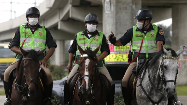 Horse-mounted police ride through the sewage-flooded streets as workers struggled to clean.
