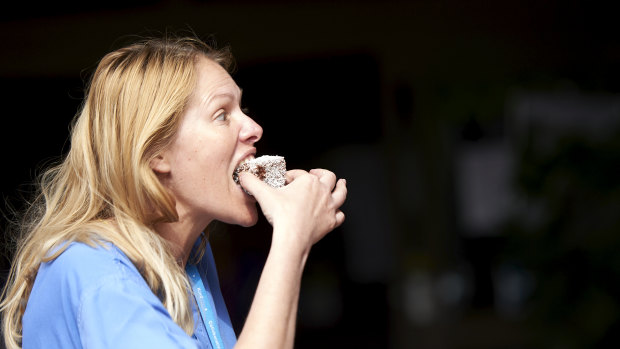 A National Health Service worker enjoys one of the lamingtons made by the Australian High Commission in London.