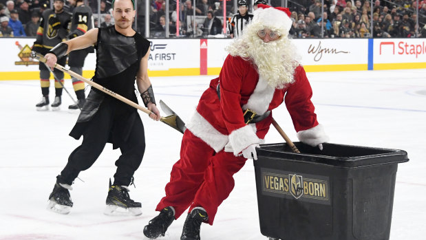 Members of the Knights Guard, including one wearing a Santa Claus outfit, clean the ice during the Vegas Golden Knights' game against the Colorado Avalanche on Monday.
