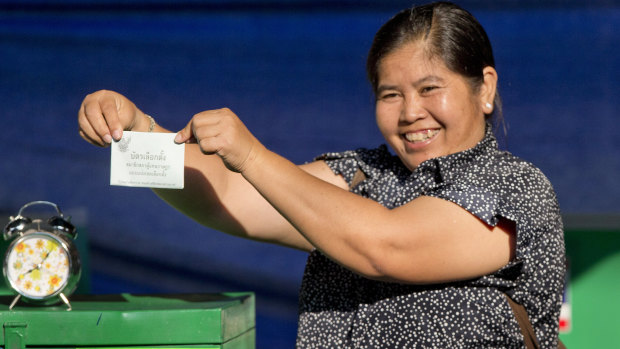 A Thai voter with a ballot paper in her hand, poses at a polling station in Bangkok, Thailand, on Sunday.