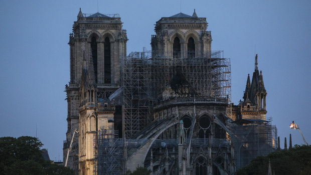 Firefighters operate on the Notre-Dame Cathedral after the fire in Paris.