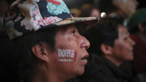 A supporter of presidential candidate Andres Manuel Lopez Obrador with the MORENA party letters painted on his cheek, celebrates Lopez Obrador's victory, in Mexico City's Alameda Central Park, on Sunday.