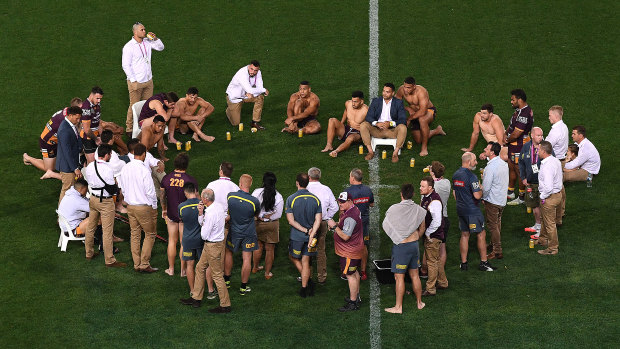 Brisbane players and staff pause for a beer on the Suncorp surface to mark the end of their season.