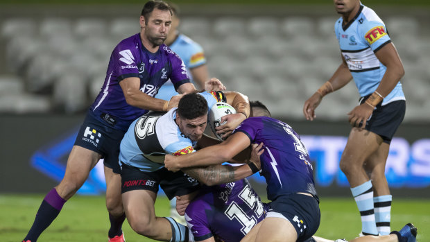 Braden Hamlin-Uele of the Sharks is tackled during the round-two match against the Storm.