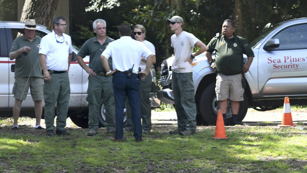 Law enforcement officials stand near where authorities say Cassandra Cline was dragged into a lagoon by an alligator and killed while trying to save her dog on Monday on Hilton Head Island, South Carolina. 