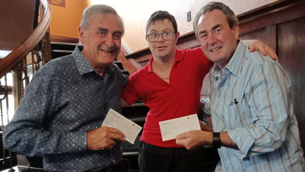 Kyle Burnell (centre) presents a cheque to Bill Baker from the Treehouse, left, and Paul Walshe from Respite Care for Queanbeyan.