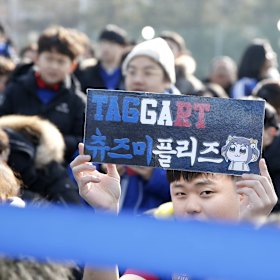 A young Suwon fans holds up a sign dedicated to Adam Taggart.