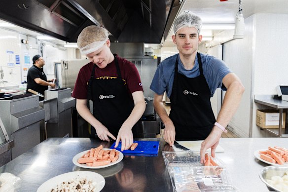 Hospitality trainees Dom Harper and Will McHutchison prepare food during the weekly Omnia Inclusive hospitality workshop in Chatswood.