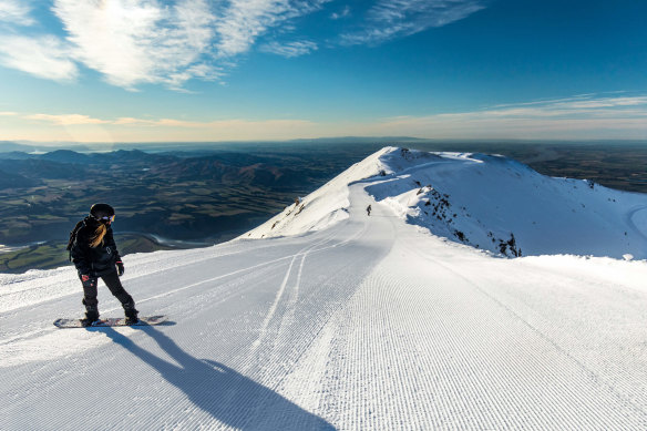 Snowboarding at Mount Hutt, near Methven, with the Canterbury Plains in the distance.