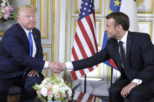 Donald Trump shakes hands with French President Emmanuel Macron in Caen, France, in 2019.