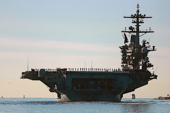 Sailors and marines line the deck of aircraft carrier USS Abraham Lincoln in 2021.
