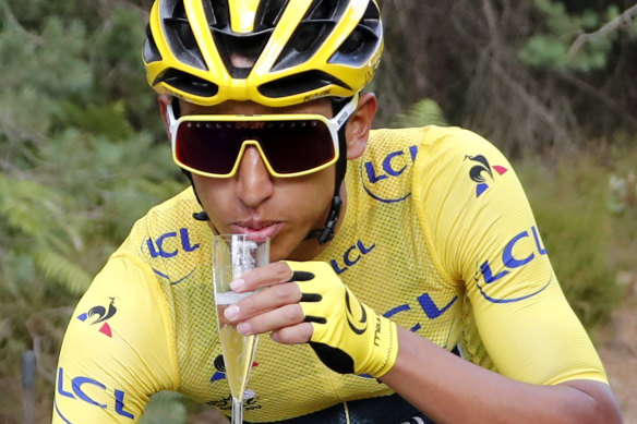 Egan Bernal takes a glass of champagne during the largely ceremonial final stage into Paris on Sunday.