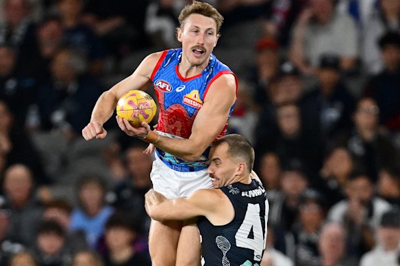 Bailey Dale handballs while being tackled by Francis Evans.