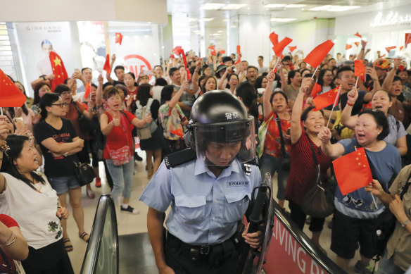 Pro-China supporters cheer after riot police arrived at the Kowloon Bay district in Hong Kong.