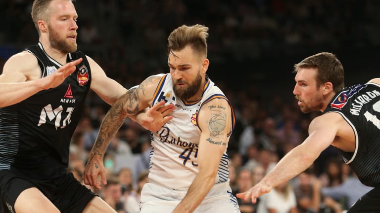 Jeremy Kendle of Brisbane, centre, under pressure from David Barlow, left, and Mitch McCarron of Melbourne.