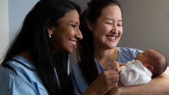 Young obstetricians, Kaushi Arulpragasam, left, and Stephanie Sii, right, with 4 day old Richie Hicks, at the Royal Hospital for Women in Randwick, Sydney. Women are taking up obstetrics in greater numbers than men now. 4th June 2021 Photo: Janie Barrett