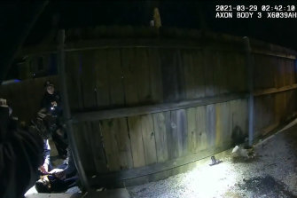 Chicago Police Department body-cam video shows officers doing CPR on Adam Toledo (lower left) after he was shot by an officer. A gun is seen on the ground by the fence, (lower centre).