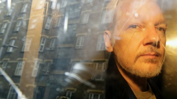 Buildings are reflected in the window as WikiLeaks founder Julian Assange is taken from court.