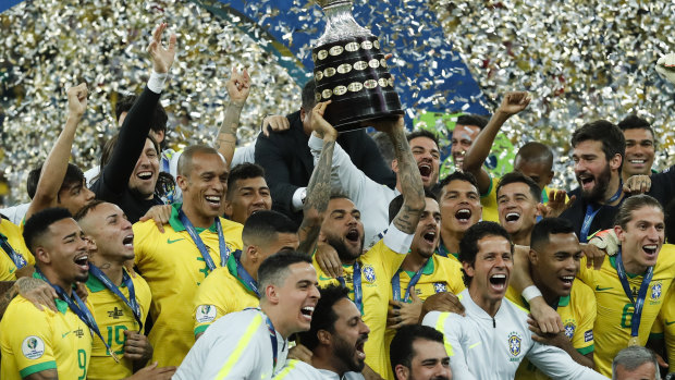 Heroes' salute: Brazil's Dani Alves lifts up the trophy after winning the final of the Copa America against Peru at the Maracana stadium in Rio de Janeiro.